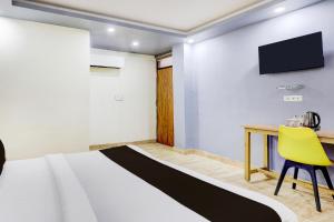 una habitación con una cama, un escritorio y un televisor en Hotel O DIAMOND INN, en Nueva Delhi