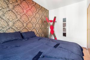 a bedroom with a bed with a red ribbon on the wall at Love Room Le Dungeon - Pézenas in Pézenas