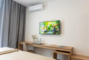 カンパーナにあるRM Campana Hotelのテーブルと壁掛けテレビ付きの部屋