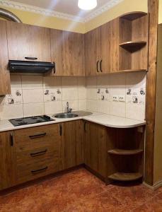 a kitchen with wooden cabinets and a sink at Підгорянка in Yaremche