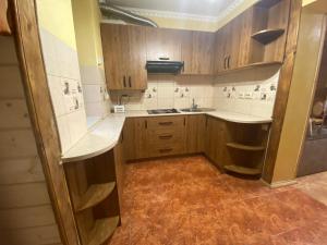 a small kitchen with wooden cabinets and a sink at Підгорянка in Yaremche