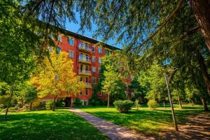 un gran edificio de ladrillo rojo en un parque en Your Home Inn at Jikia's Green House-Central Tbilisi, en Tiflis