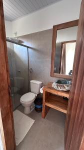 a bathroom with a toilet and a sink and a mirror at Pousada Tamikuã in Caraíva +36 photos