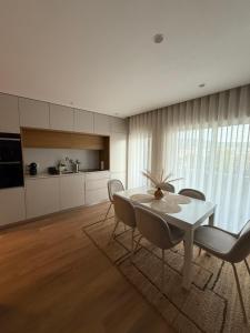 Una cocina y un comedor con mesa y sillas. en Apartamento do Raio, en Braga