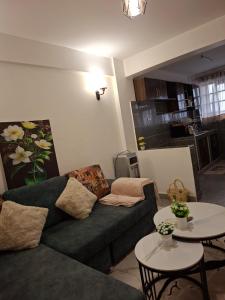 a living room with a couch and two tables at Ben's Apartment - Near Ngong Karen in Nairobi