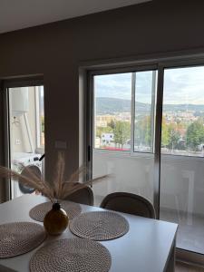 Un comedor con una mesa con sillas y ventanas. en Apartamento do Raio, en Braga 8 fotos más