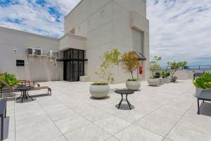 a building with a patio with potted plants on it at Apartamento Moderno e Completo em Curitiba in Curitiba
