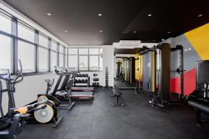 a gym with treadmills and machines in a room at Apartamento Moderno e Completo em Curitiba in Curitiba