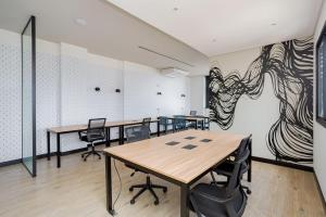 an office with tables and chairs and a drawing on the wall at Apartamento Moderno e Completo em Curitiba in Curitiba +38 photos