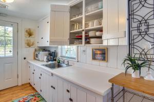 a kitchen with white cabinets and a sink at Steps to Eats and Craigville Beach! Cape Cod Cottage in Centerville