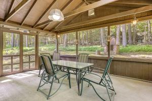a screened in porch with a table and chairs at Boat, Hike and Fish Rustic Greenwood Retreat in Arlington