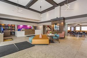 a lobby with a table and chairs and a restaurant at Best Western Plus West Edmonton in Edmonton