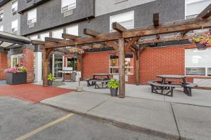 a patio with picnic tables in front of a brick building at Best Western Plus West Edmonton in Edmonton