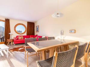 a living room with a table and chairs and a red couch at Appartement cosy pour 6 près de l'ESF et du parking - FR-1-314-254 in Morzine