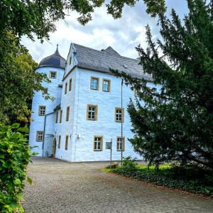 a large white building with a black roof at Schlosshotel Eyba in Saalfeld