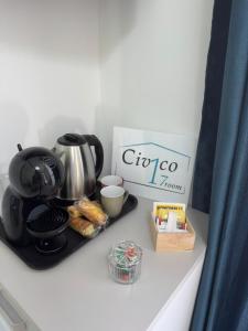 een dienblad met een koffiepot en een doos op een aanrecht bij Civico17room in Cirò Marina +32 foto's
