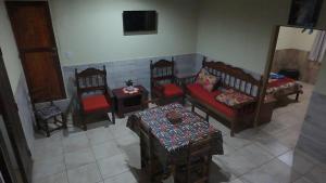 a living room with chairs and a couch and a tv at La Reina in Eldorado