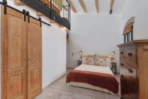 a bedroom with a bed and a wooden cabinet at Marina Vila House, Vista Playa in El Masnou