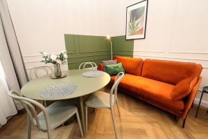 a living room with a couch and a table at Prestiżowy Apartament Rosette Residence 2 z tarasem AC Progres in Toruń