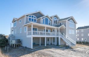 a large house with a balcony on a beach at C9703 Oceanfront Luxury Retreat in Carova, Private Pool & Hot Tub - Prices Reduced! in Corolla