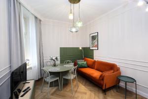 a living room with a couch and a table at Prestiżowy Apartament Rosette Residence 2 z tarasem AC Progres in Toruń
