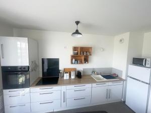 een keuken met witte kasten en een witte koelkast bij Le 41a in Chartres