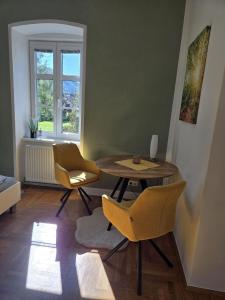 ein Wohnzimmer mit Tisch und Stühlen und einem Fenster in der Unterkunft Appartements Maximilian in Göstling an der Ybbs + 46 Fotos