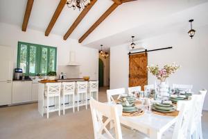 a kitchen and dining room with a white table and chairs at Villa Kaia in Kringa