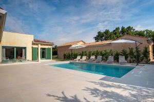 a swimming pool with chairs and a house at Villa Kaia in Kringa