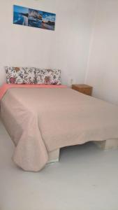 a bedroom with a large bed with a blanket on it at Chentes Place in Barra de la Cruz