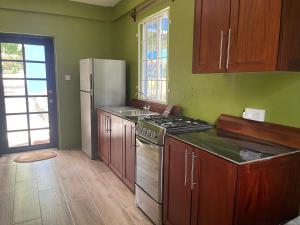 a kitchen with a stove and a refrigerator at Cinnamon Cottage - Peaceful retreat in nature in Soufrière