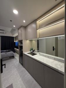 a kitchen with a sink and a bed in a room at Apartment Bella Pakuwon City Mall Surabaya 3 pax in Surabaya