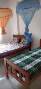 a bedroom with two beds with bluenets at Ovinro Rest in Anuradhapura