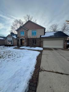 a house with snow in front of it at Cozy & Spacious Michigan Retreat in Livonia