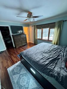 a bedroom with a bed and a ceiling fan at Cozy & Spacious Michigan Retreat in Livonia