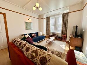 Una sala de estar con un sofá azul y un televisor. en Gorgeous Home In Ealing London, en Brentford