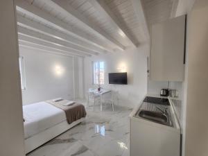 a white room with a bed and a kitchen at Residence Jasmin 2P B in Turate