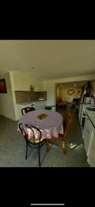 a room with a table and a kitchen with a table and chairs at GLAM in Saint-Jean-dʼArvey