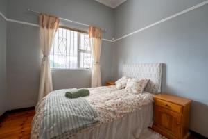 un dormitorio con una cama y una ventana en 2 Stone's Throw, en Gqeberha 31 fotos más