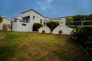 una casa blanca con un patio delante en 2 Stone's Throw, en Gqeberha