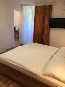 a large bed in a room with a window at Bartók Apartman in Harkány