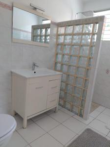 une salle de bain avec un lavabo, des toilettes et un miroir dans l'établissement Exceptional villa KODEÏA - private spa & panoramic view, à Sainte-Marie 10 autres photos