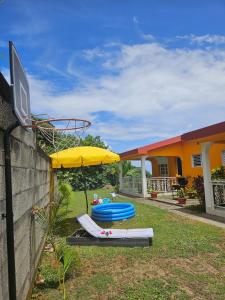 un patio avec un parasol jaune et deux bateaux bleus dans l'établissement Exceptional villa KODEÏA - private spa & panoramic view, à Sainte-Marie