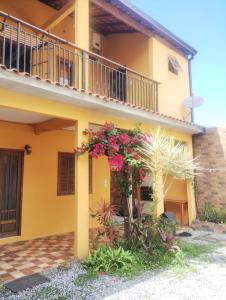 a yellow house with flowers on the side of it at Casa Amarela da Prainha de Mambucaba - Piscina aquecida in Paraty