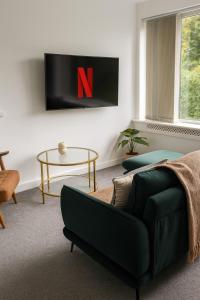 a living room with a green couch and a tv at Comfortable 3 bed in Winchester - Parking in Winchester