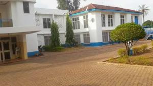 a white house with a tree in front of it at Heritage Hotel in Trofwi