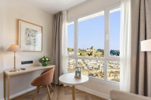 a room with a window with a table and a chair at Sercotel HMO Martina in Granada +16 photos