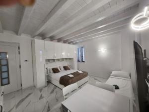 a white room with a bed and a table and chairs at Residence Jasmin 2P B in Turate