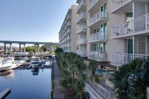 a large apartment building with a marina and palm trees at Harbourgate Marina Club in Myrtle Beach