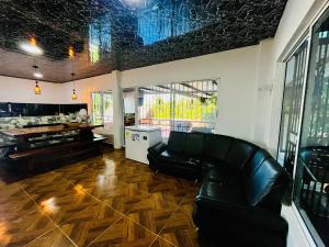 a living room with a leather couch and a table at Villa Paraíso Nápoles in Doradal